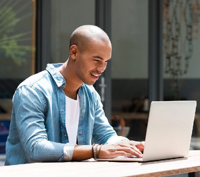 A man sitting at a table with a laptop.